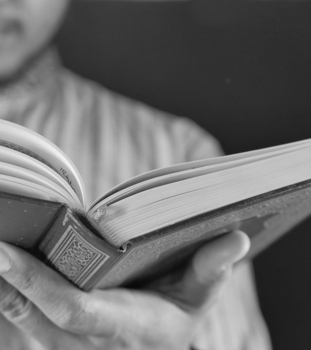 Muslim mans hand reading quran at night selective focus. Muslim mans hand reading quran at night .